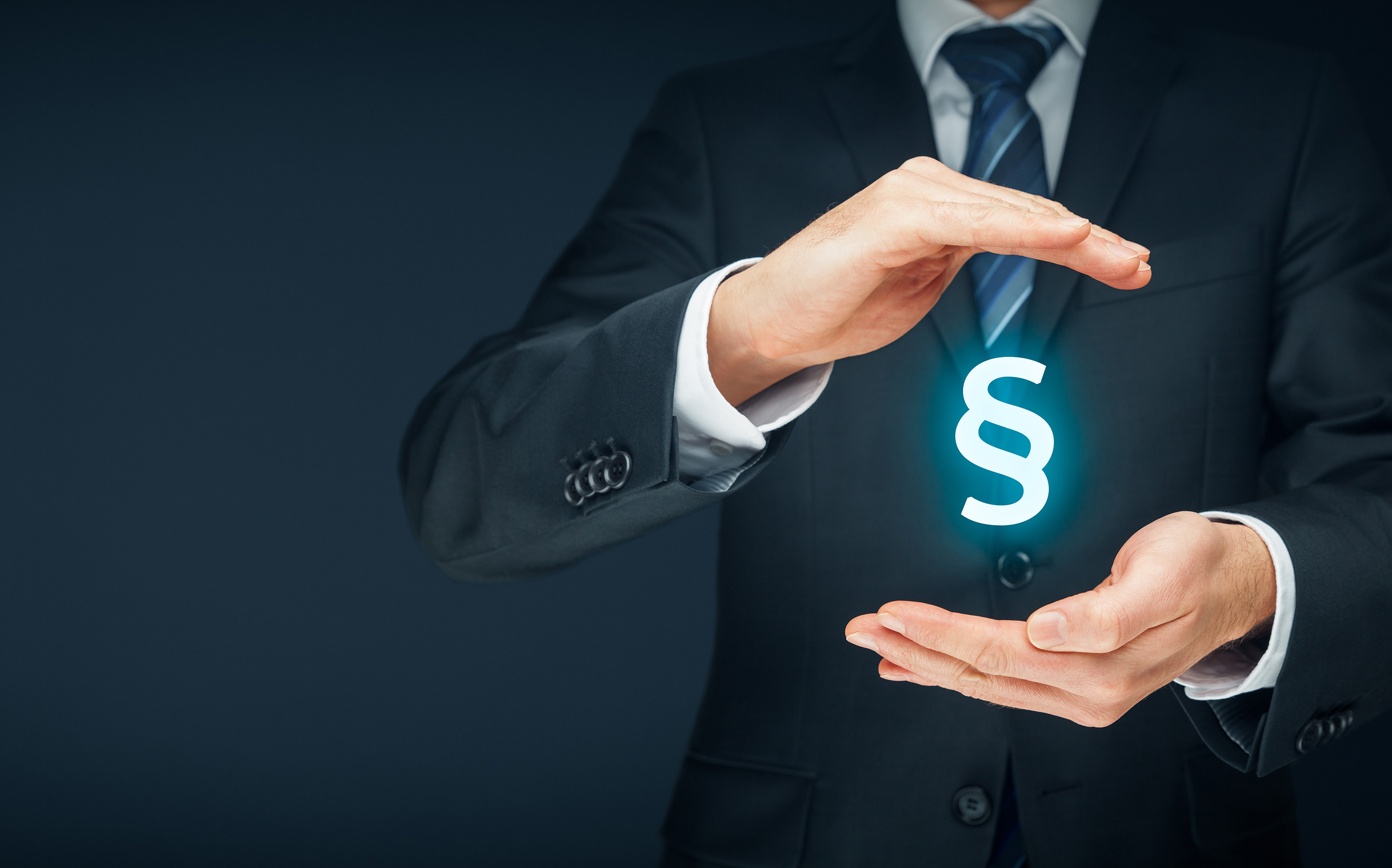 Man i kostym har ett flygande paragraf-tecken mellan sina händer